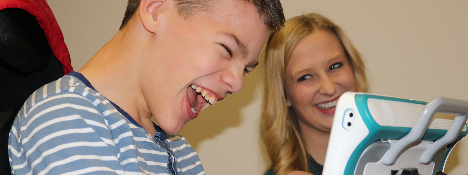 Kaden Bowen and speech-language pathology graduate student Audrey Hartwell share a laugh during Kaden's session at the Barkley Speech Language and Hearing Clinic.