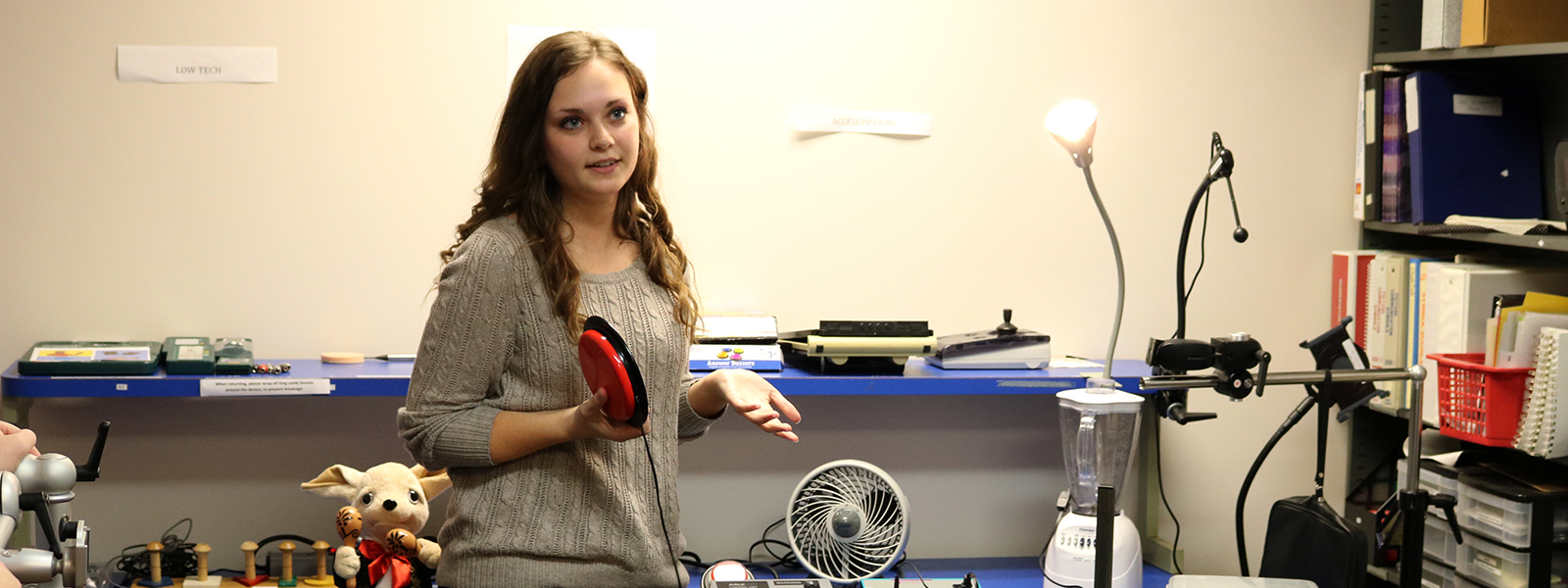 Madison Routier, a speech-language pathology graduate student explains various AAC methods and devices in the AAC Lab.