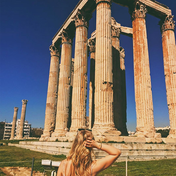 Student Standing in front of columns in Greece