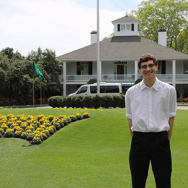 Student standing in front of clubhouse