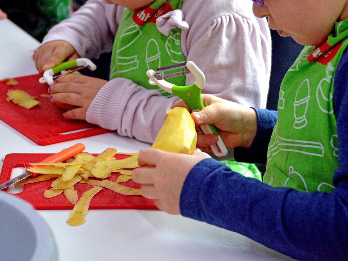 Children peeling potatos.