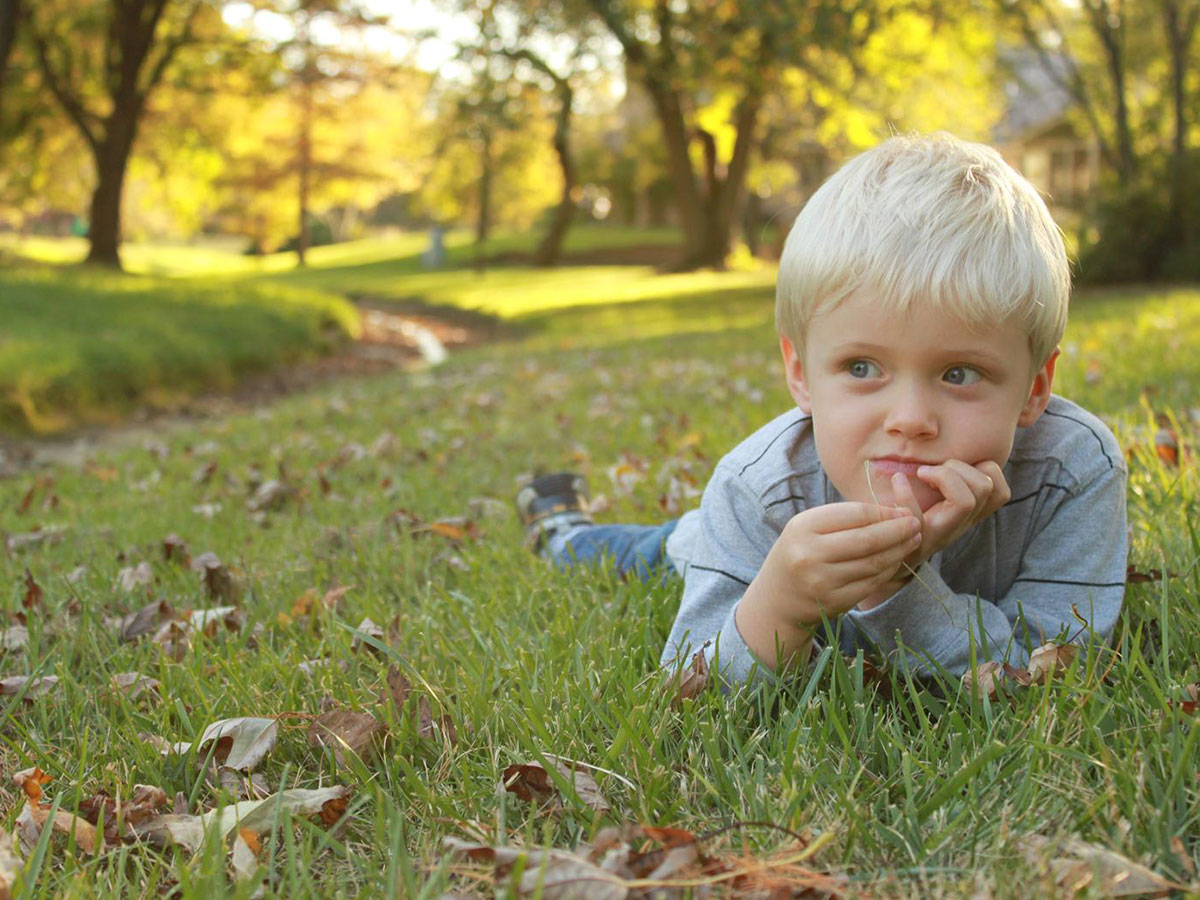 Child laying in grass.