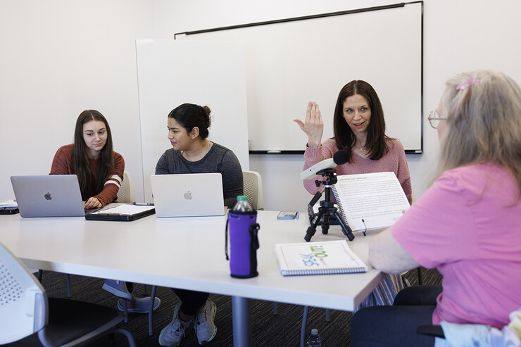 Jessie Kohn (second from right), lecturer in special education and communication disorders, gives instructions to Rhonda Heiserman (far right) of Lincoln during her clinic session. Graduate students Claire Streeter (far left) and Nayeli Cruz take notes. (Craig Chandler/University Communication and Marketing)