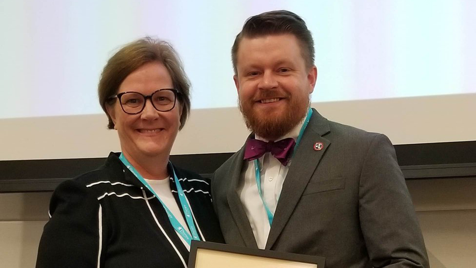 Josh Sevier receives the Nebraska State Clinical Achievement Award from Sherri Jones, current president of the Nebraska Speech-Language-Hearing Association.