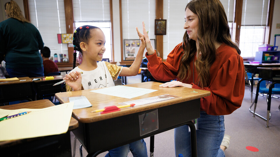 Morgan Twiss high fives a student in her classroom at Elliott Elementary. 