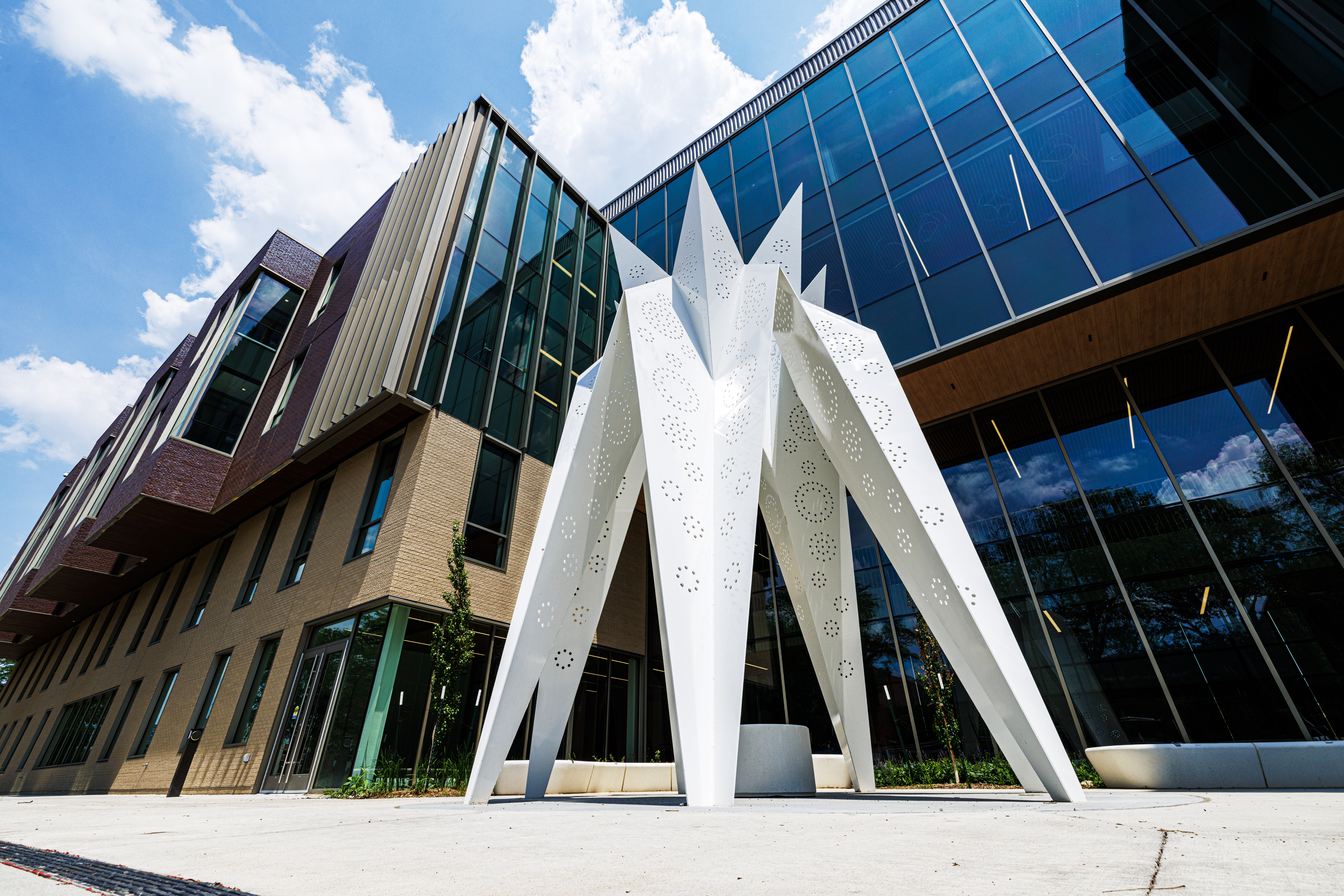 A white geometric sculpture stands outside of the west entrance to Carolyn Pope Edwards Hall. 