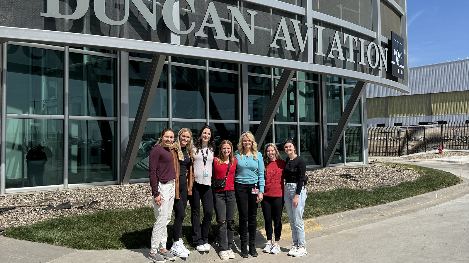 Husker students pose for a group photo outside Duncan Aviation during their class tour