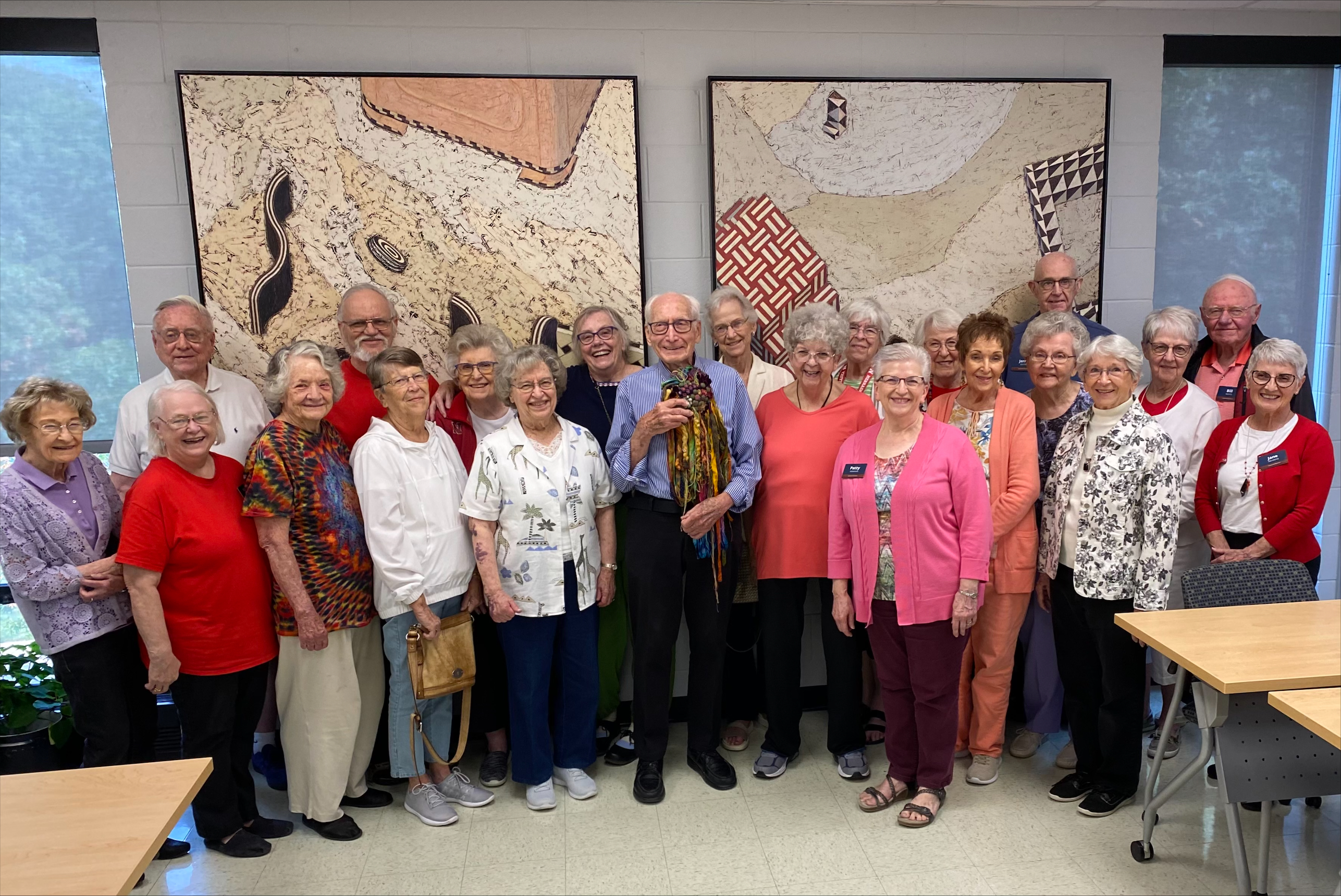 Eastmont Towers residents pose for an image with Dr. Robert Hillestad in the center holding a piece of art.