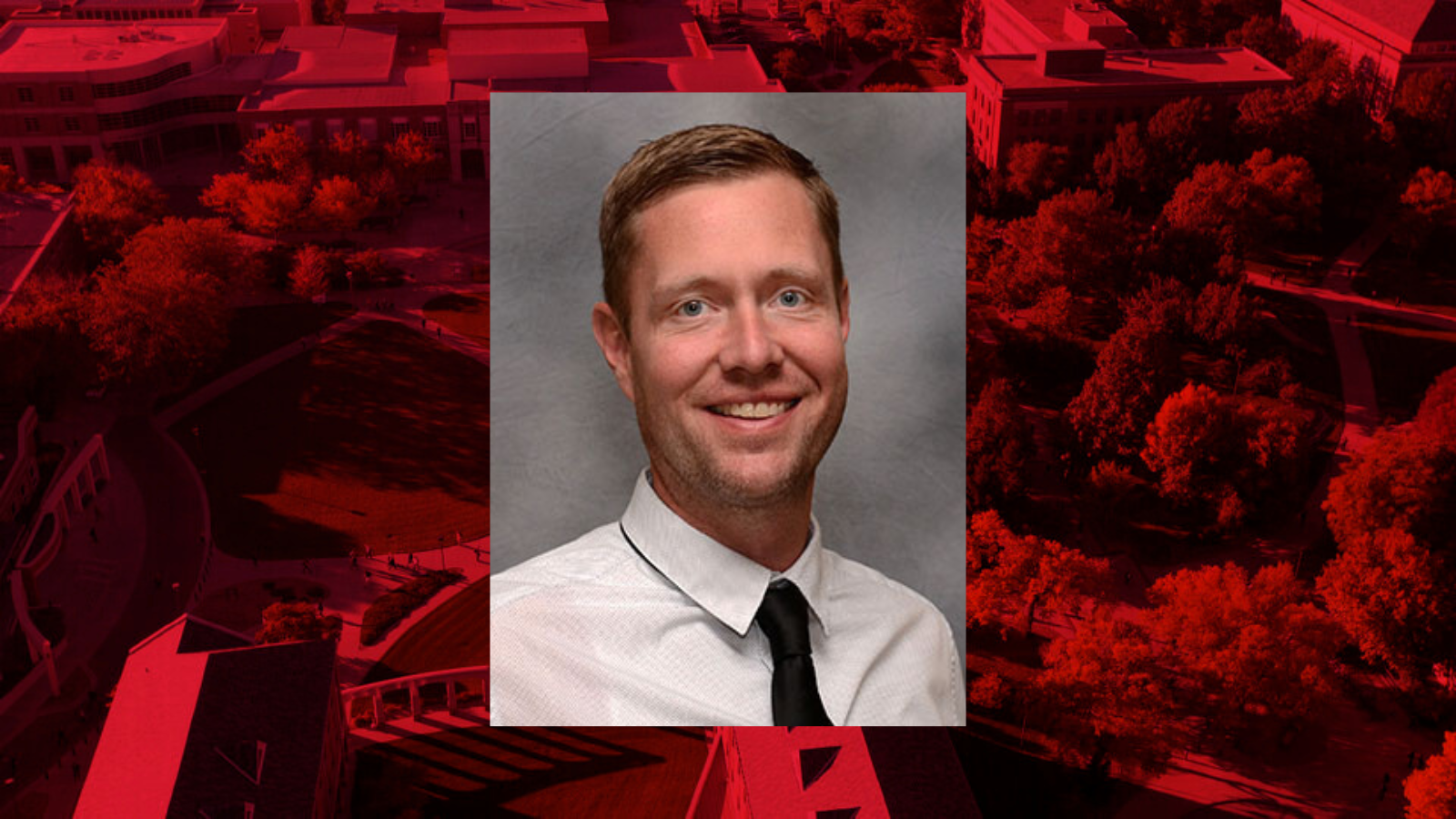 Professional headshot of Jason Thomsen on a red background.