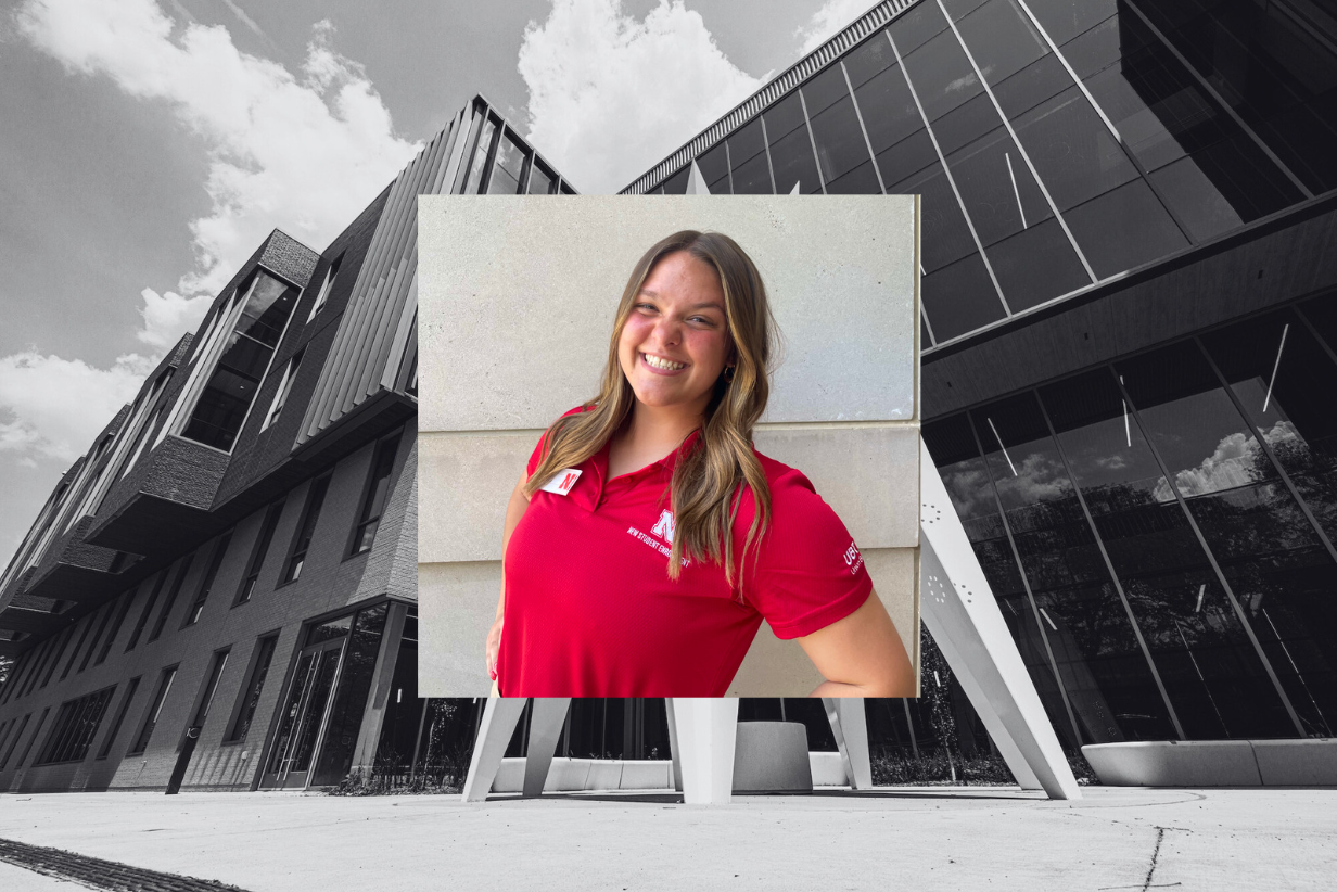 Myah Anderson wears a red New Student Enrollment polo and smiles for a photo outdoors. The photo is placed on a black and white image of Carolyn Pope Edwards Hall. 