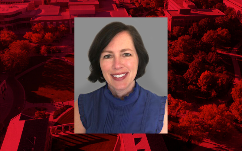 Professional headshot of Tina Horan on a red background. 
