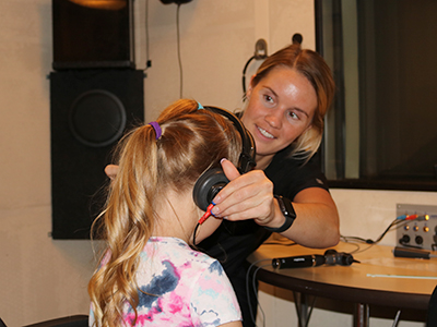 a Husker AuD student tests a young girl's hearing at the Barkley Speech Language and Hearing Clinic