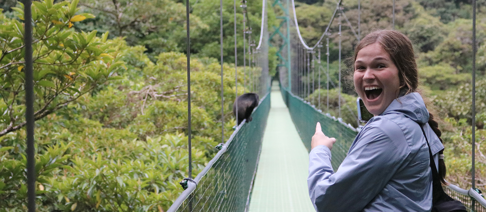 a Husker student reacts to seeing a monkey on a suspension bridge in Costa Rica
