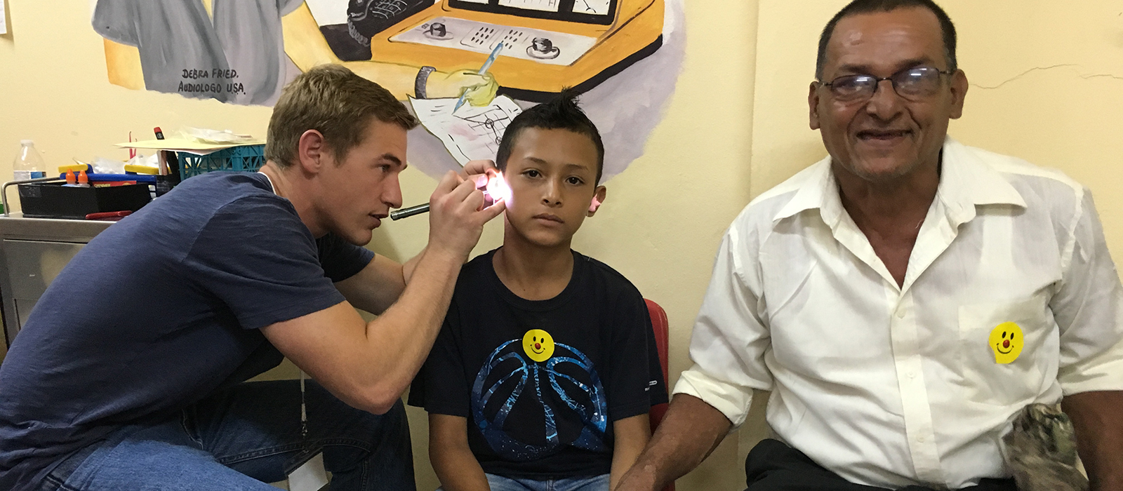a Husker student performs a hearing exam on a young boy in Nicaragua