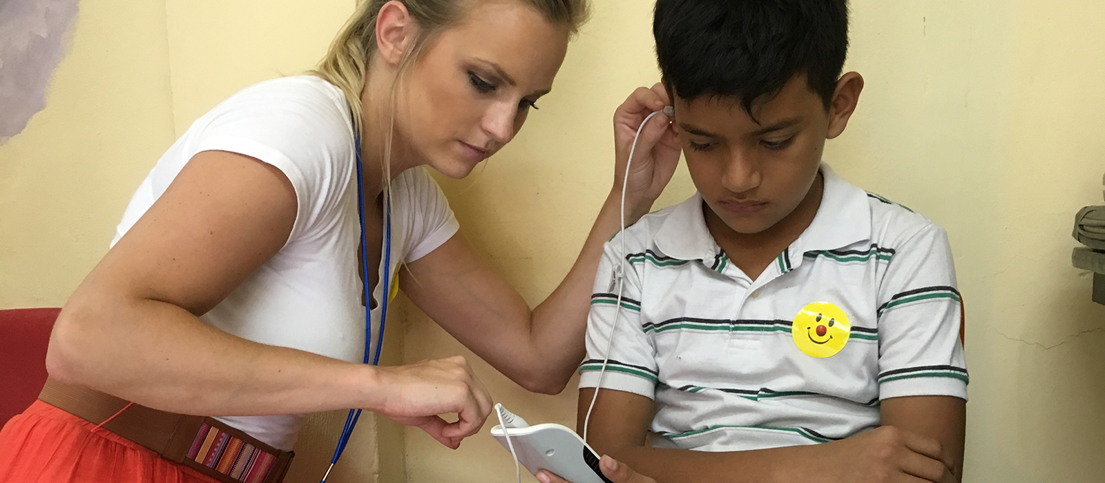 a Husker student conducts a hearing evaluation on a young boy in Nicaragua