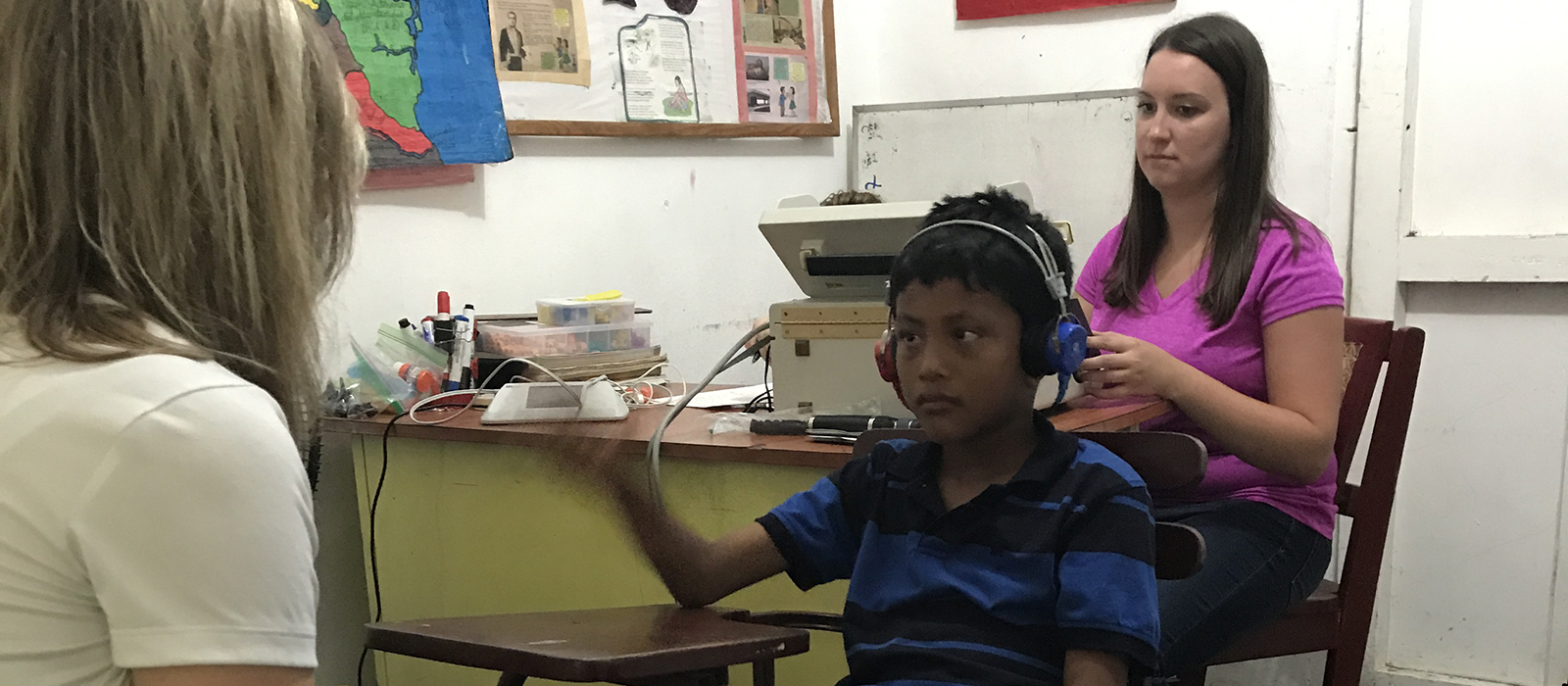 a Husker student conducts a hearing evaluation on a young boy in Nicaragua