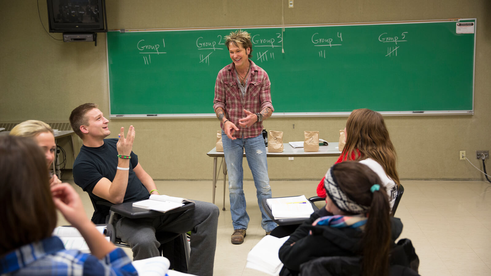 Student teachers share a laugh in a classroom.