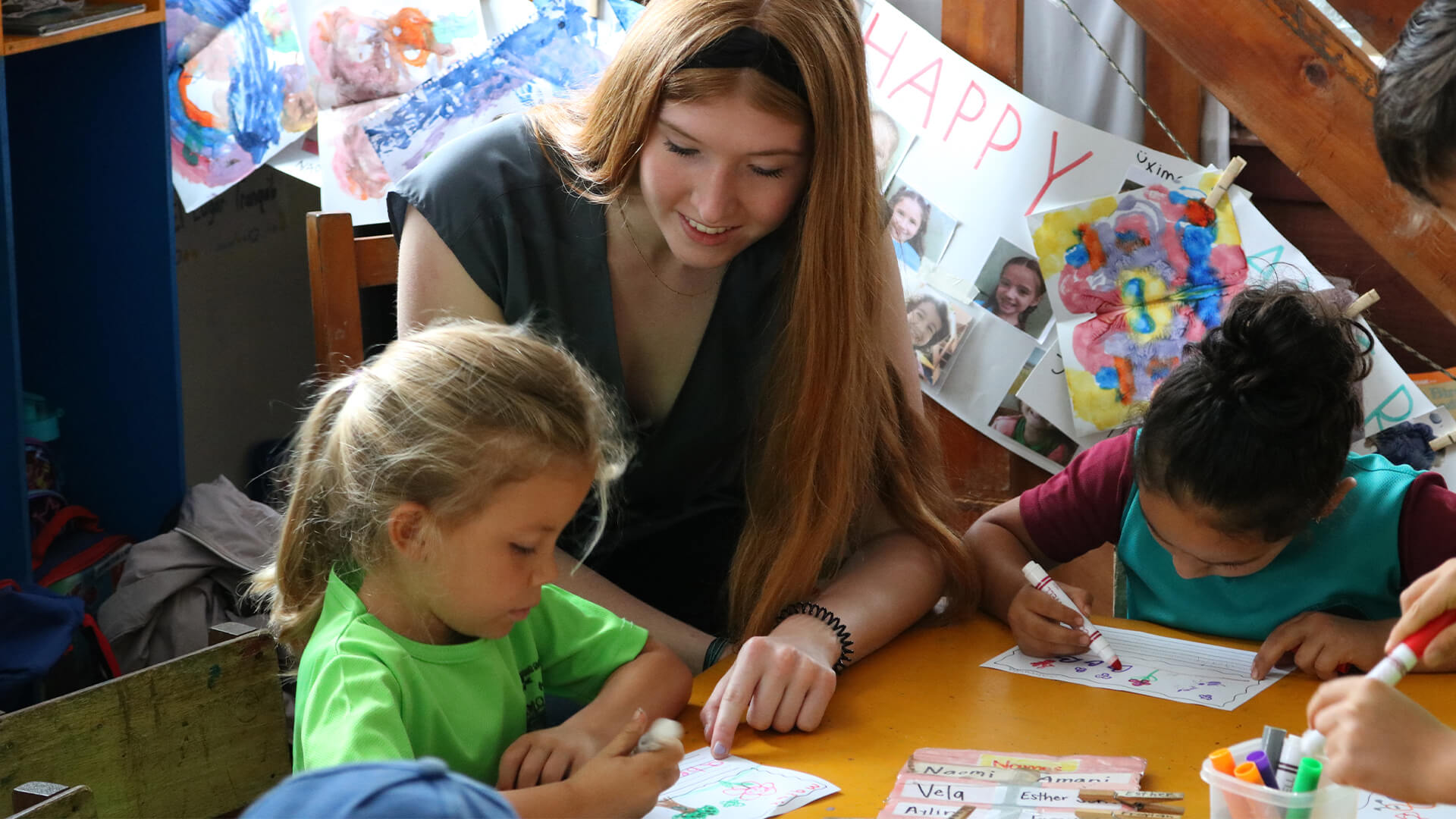 Student working with elementary students in classroom