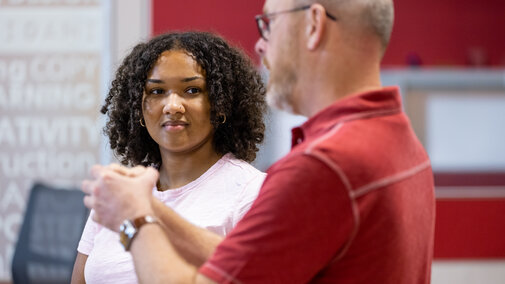A student and professor speaking with each other. 