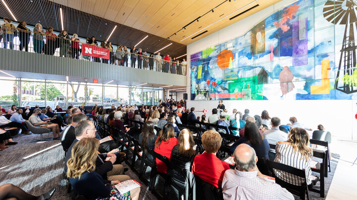 A large group gathers in the Living Room of Carolyn Pope Edwards Hall. 