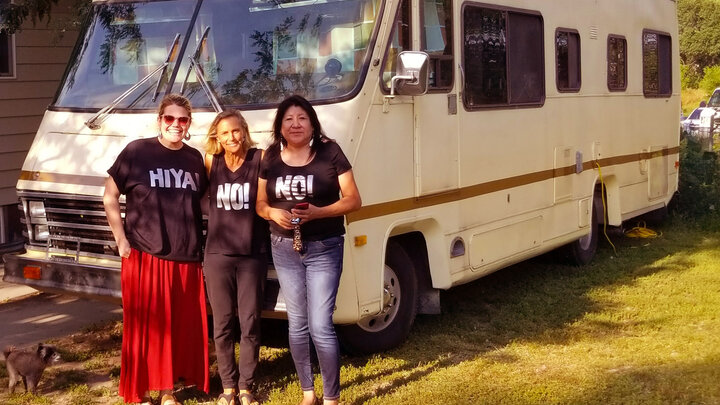 Three people standing in front of a motorhome on a South Dakota Native American reservation.