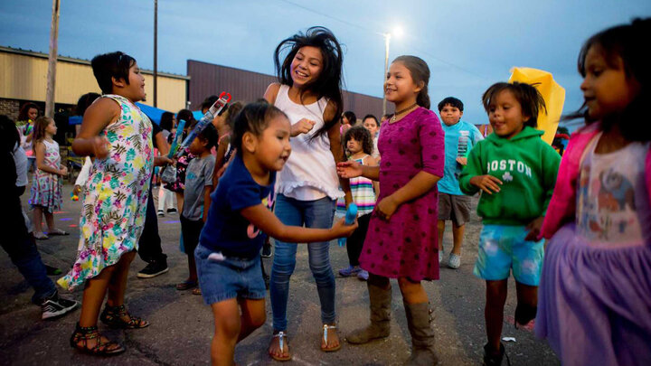 Youth playing and dancing outdoors at dusk. 