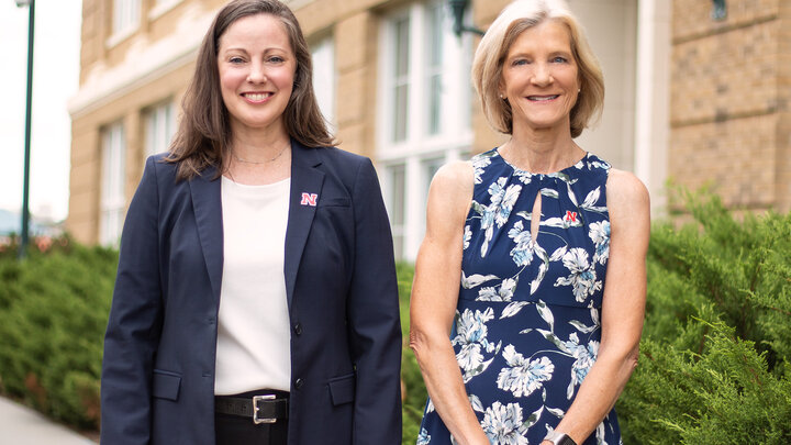 Lorey Wheeler (left) and Susan Sheridan stand outdoors smiling for a photo. 