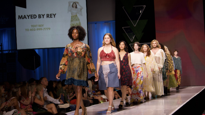6+ individuals wearing handmade looks by ReyAnna Moore walk the runway at Omaha Fashion Week.