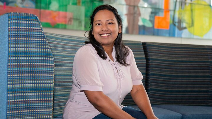 Saima Hasni sits on a blue chair in Carolyn Pope Edwards Hall