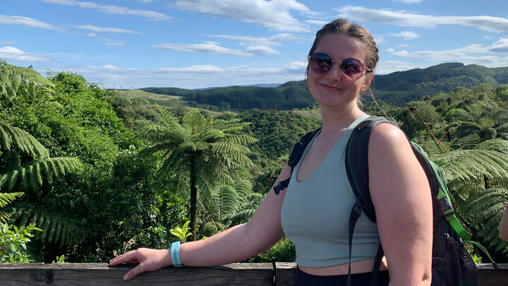 Olivia DeBrie poses for a photo on a platform above the landscape in New Zealand