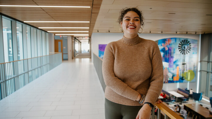 Azcia Fleming smiles for a photo in Carolyn Pope Edwards Hall on the walkway over the living room