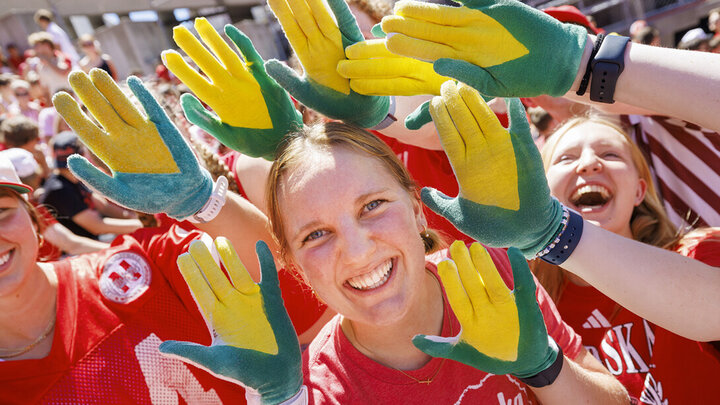 Carrie Wehrman and friends show off her corn gloves at the Husker football game Aug. 31