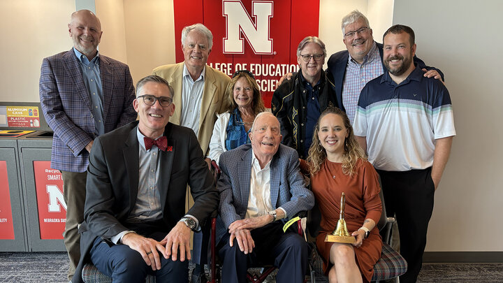 Ranae Duncan holds her award for a group photo with her family and the Battey family as well as CEHS Interim Dean Nick Pace