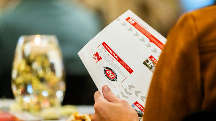An attendee at the CYFS 20th anniversary celebration Nov. 19 takes a look at the special edition 2024 CYFS Annual Report.