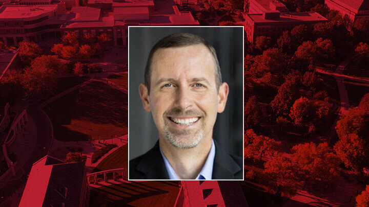 Jeff Reese headshot centered on background image of UNL campus with red overlay