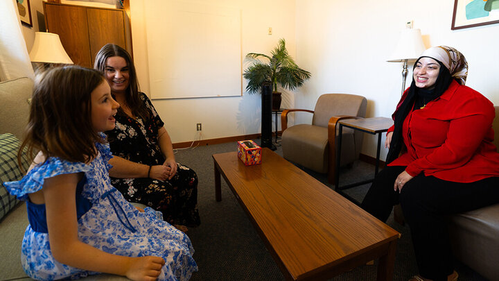 Kadeja Alkanass, a first-year graduate student in the Department of Child, Youth and Family Studies, smiles while listening to seven-year-old Stella Buhrman talk excitedly about her favorite birds in the department's Couple and Family Clinic on East Campus. Jamie Buhrman, Stella's mother, is also a first-year student in the program. Both Alkanass and Buhrman provide therapy in the clinic.