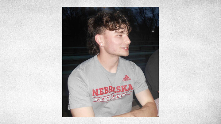 gray textured background with photo of Nathan Washburn wearing a gray Nebraska football t-shirt and looking off to the right of the photo