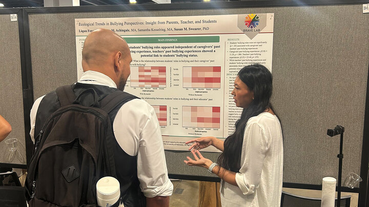 Jenny Feng discusses her research poster at the American Psychological Association Annual Convention