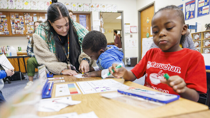 Crandall Blake helps a student in her kindergarten classroom during her student teaching