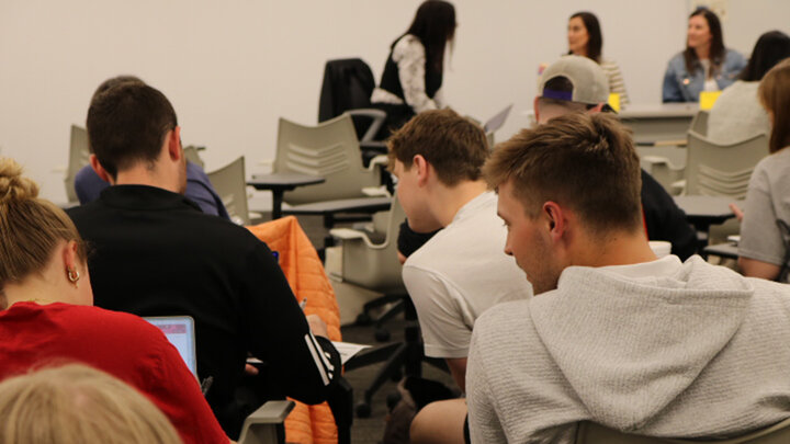 students in SPED 201 discuss with each other while panelists from Elliott Elementary prepare to talk to the class
