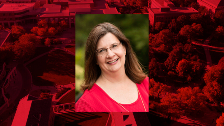 Professional headshot of Barbara Schousha on a red background.