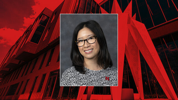 headshot of a person with dark hair and glasses, overlaid on a red-toned building and abstract sculpture background.