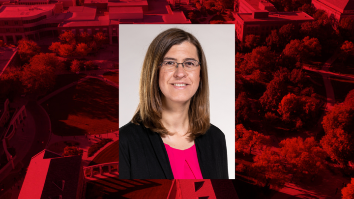 Professional headshot of Elizabeth Niehaus on red background. 