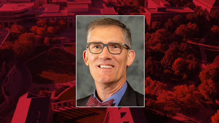 Professional headshot of Nick Pace on a red background. 