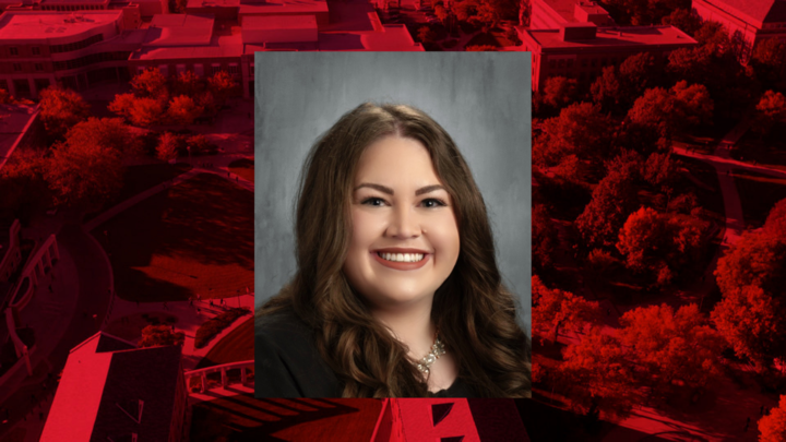 Professional headshot of Rachel Hruza on red background. 