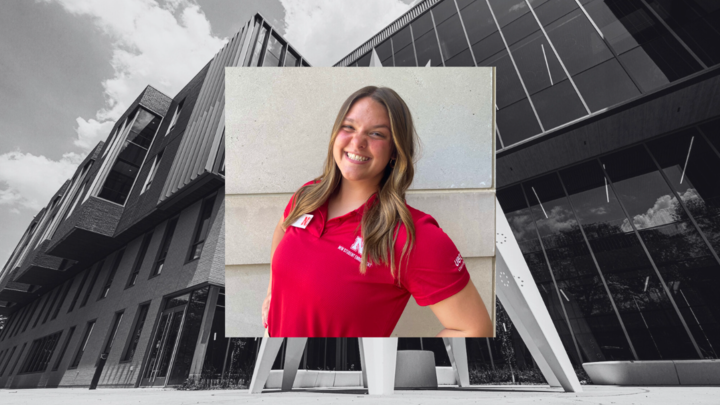 Myah Anderson wears a red New Student Enrollment polo and smiles for a photo outdoors. The photo is placed on a black and white image of Carolyn Pope Edwards Hall. 