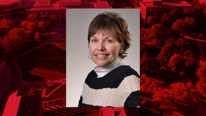 Professional headshot of Teri Kaluza on a red background. 