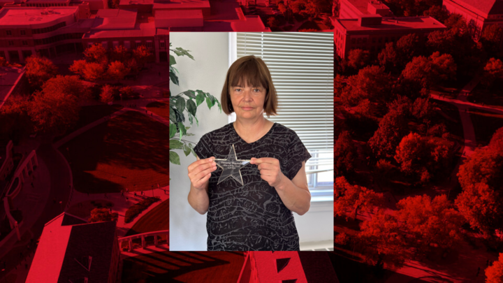 Verona Skomski stands in an office holding the CEHS Staff Star Award