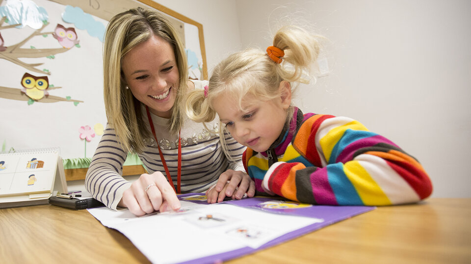 Instructor and Child looking at a workbook
