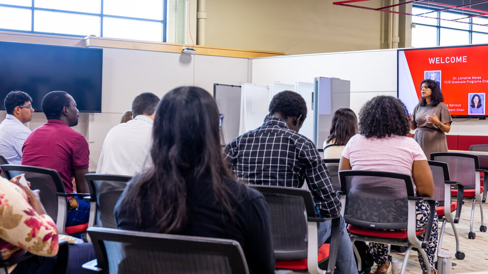 A group of students listening to a speaker. 